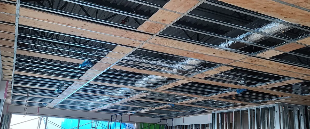 Steel stud wall framing on a high-rise construction site at sunset — JEGO Walls & Ceilings BC
