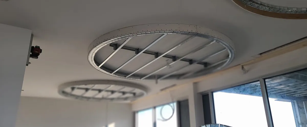 Circular suspended ceiling steel framing detail with laser level — commercial interior BC